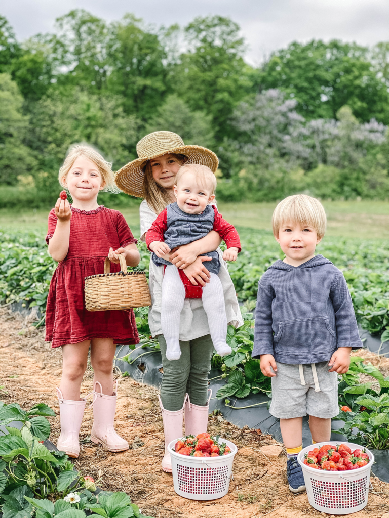 Our four children standing in the strawberry field