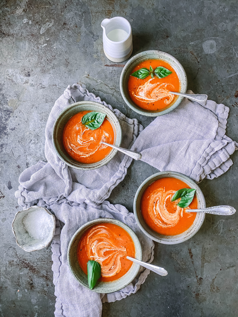 tomato soup with swirl of heavy cream and fresh basil