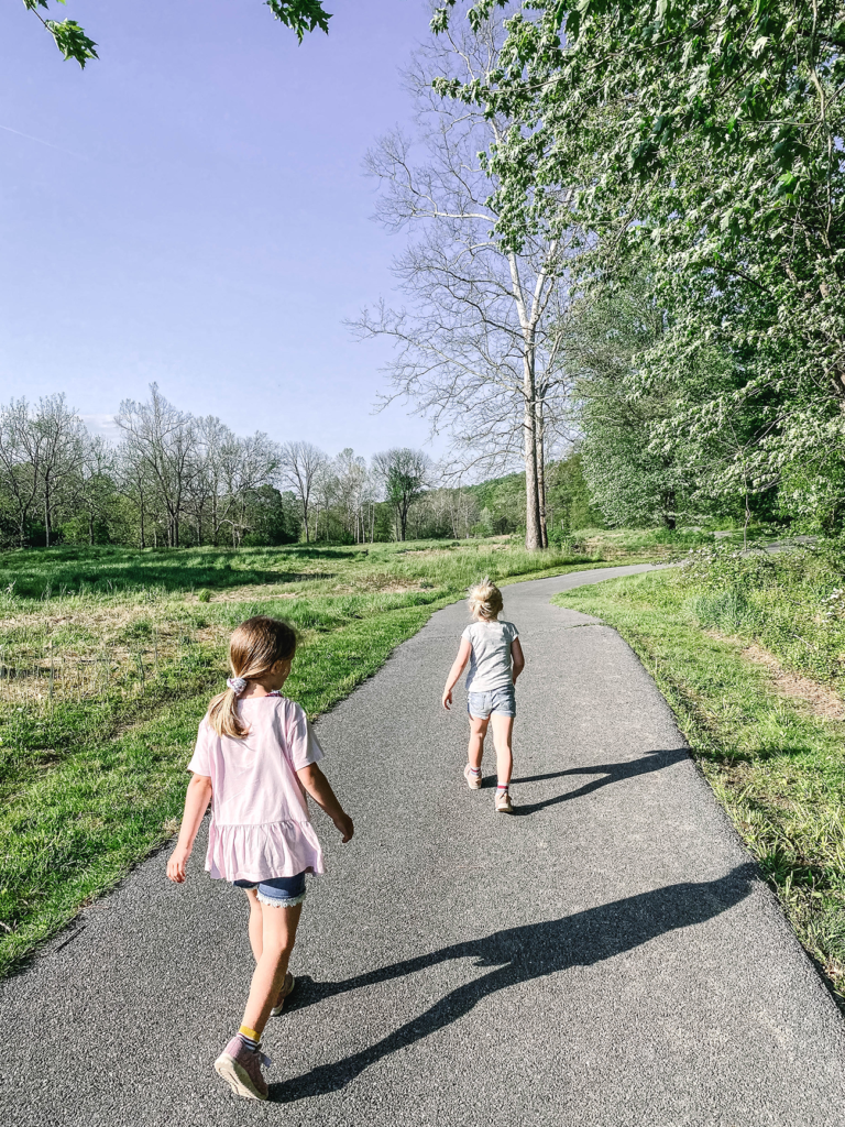 Girls walking on a paved path on a sunny day