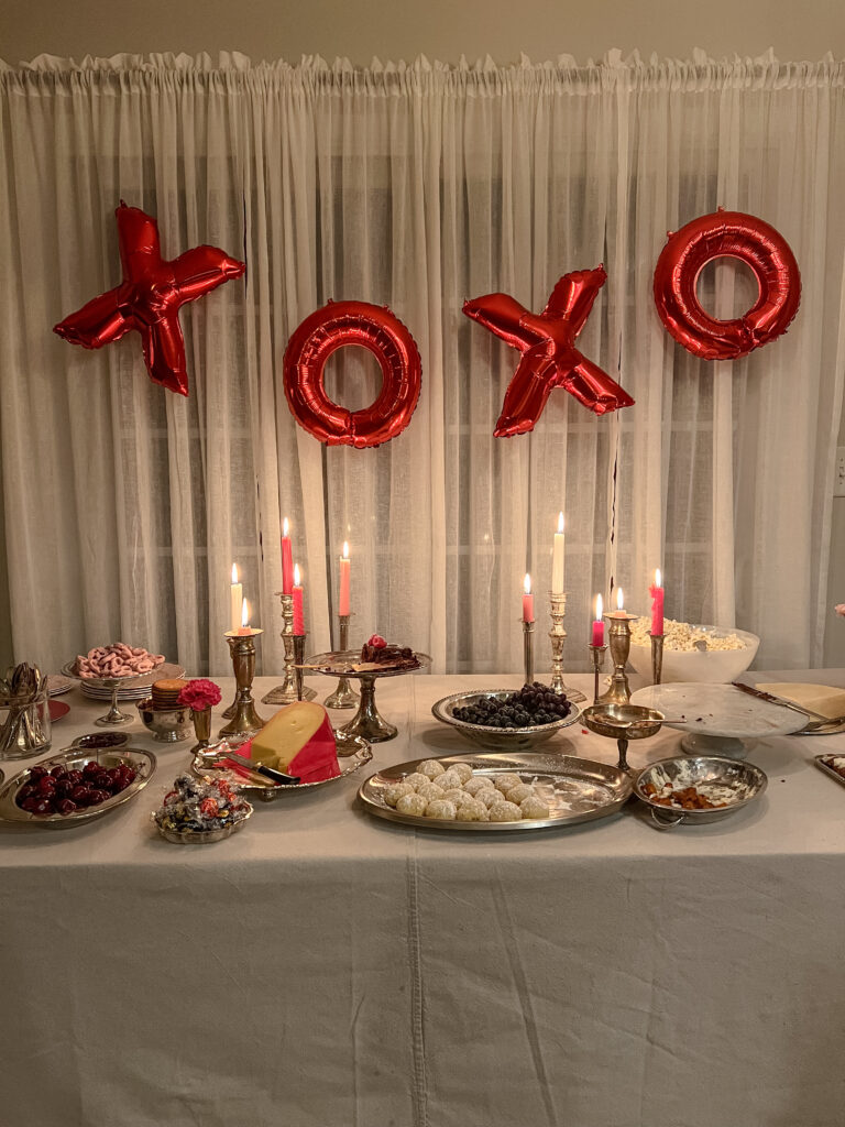 Valentine's Day party food table with balloon banner