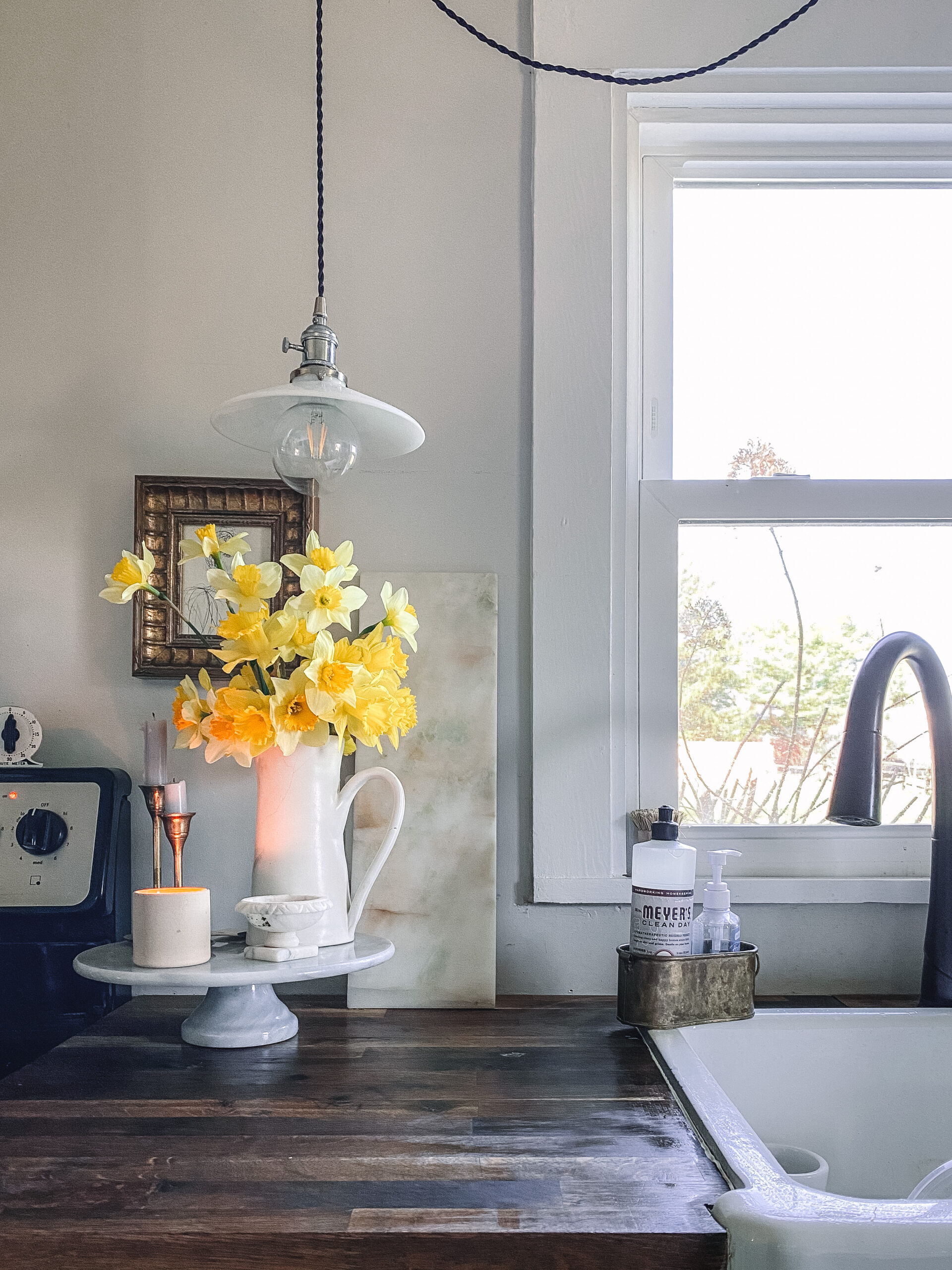 Daffodils in a pitcher on a rustic kitchen counter